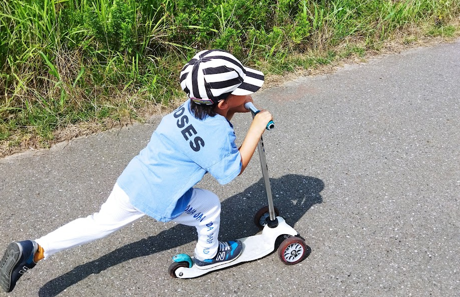 小学生がキックボードで全力疾走する姿